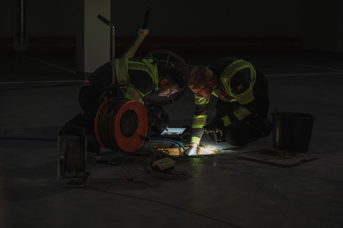 Bilde av to Spylespesialister som arbeider med avløpsrør