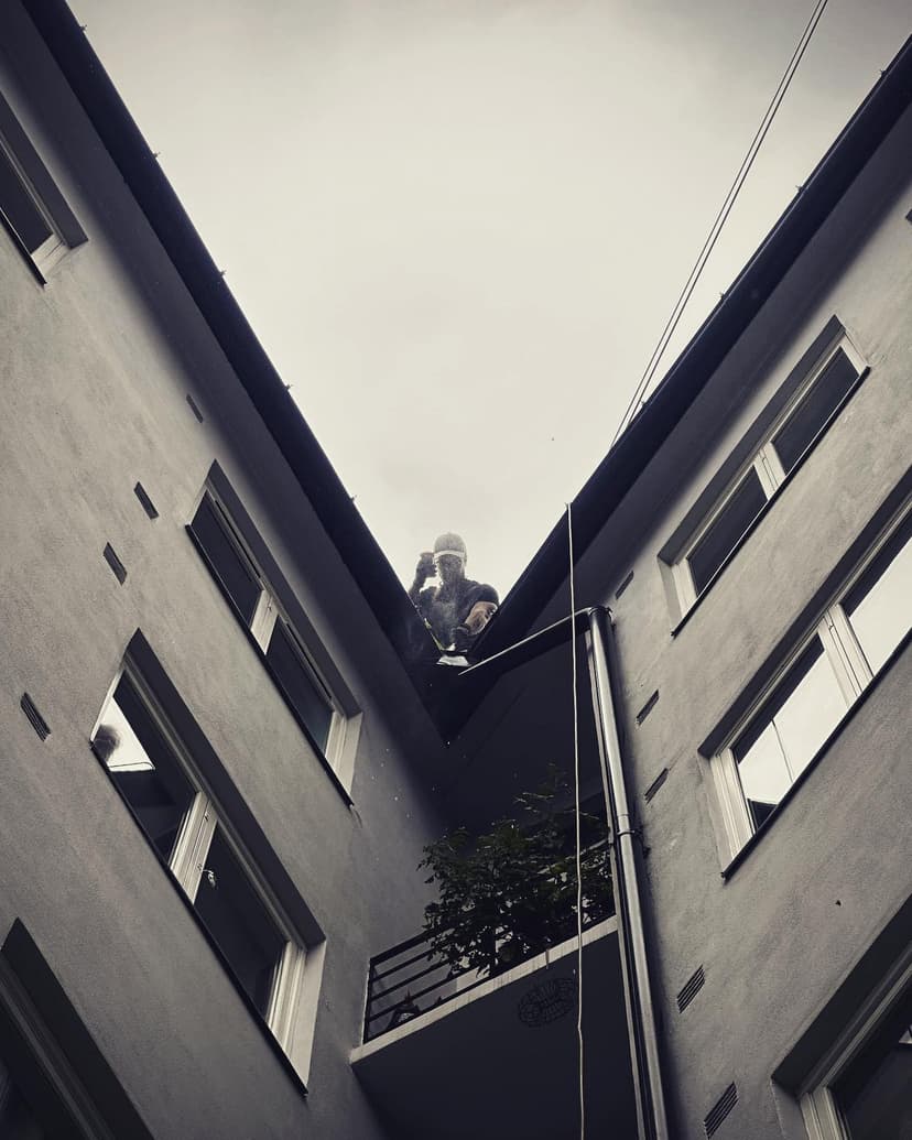 Bilde av spylespesialist som spyler takrenner og nedløp på borettslag