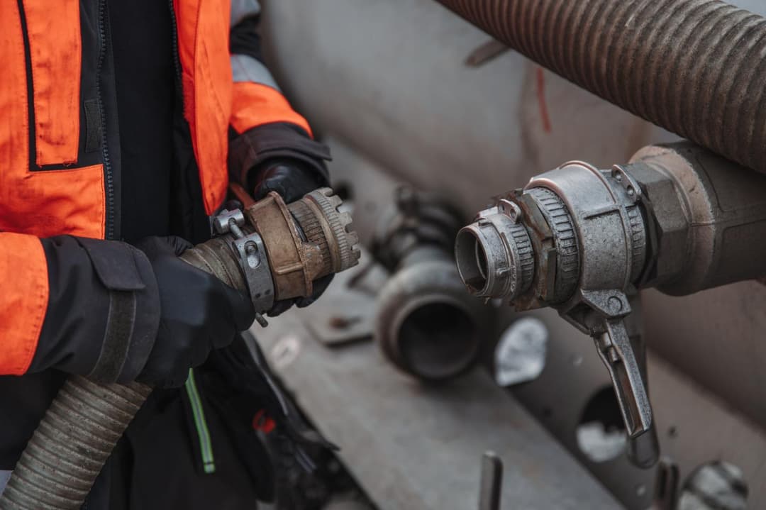 Bilde som viser spylespesialist som kobler på sugeslangen